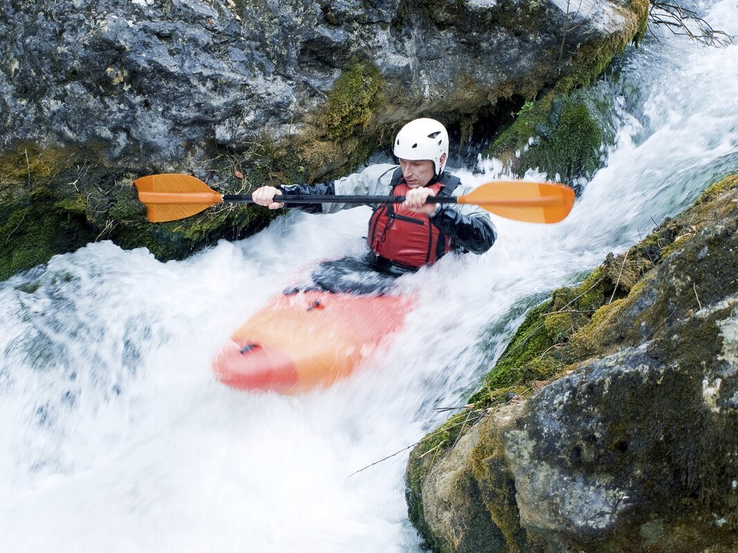 Person kayaking through white water rapids.