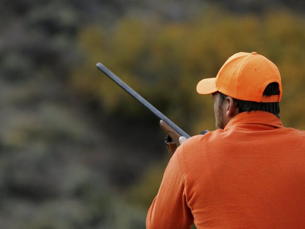 Hunter with rifle wearing all orange
